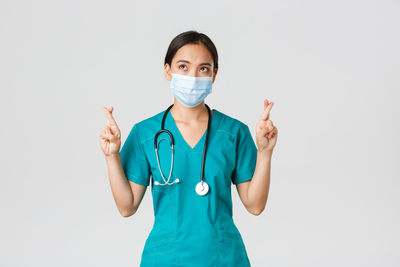 Portrait of young woman standing against white background