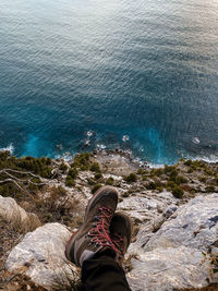 Low section of person on rock by sea