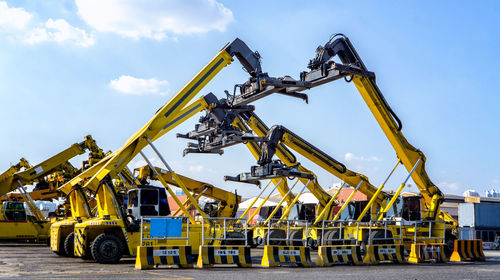 Low angle view of cranes against sky