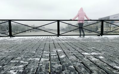 Rear view of woman with umbrella against sky