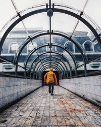 Rear view of man walking in train