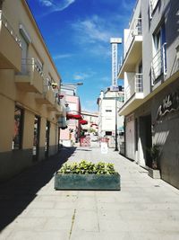 Alley amidst buildings in city against sky