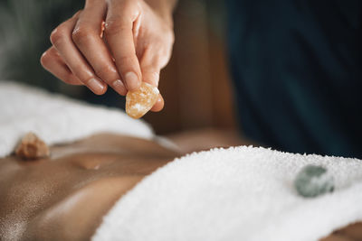 Ayurvedic practitioner using gemstones and crystals for healing female patient chakras