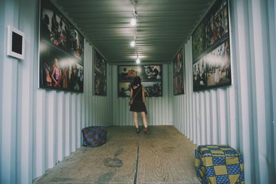 Rear view of woman standing by photographs