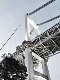 Low angle view of suspension bridge against sky