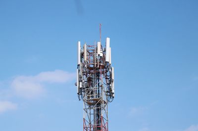 Low angle view of communications tower against blue sky