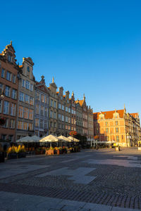 Buildings in city against clear blue sky
