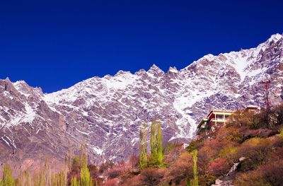 Scenic view of snowcapped mountains against clear blue sky