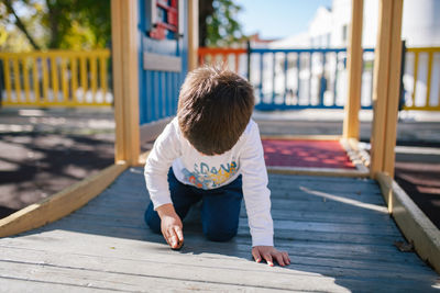 Boy playing on wooden floor at playground