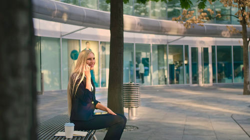 Young woman sitting on chair outdoors