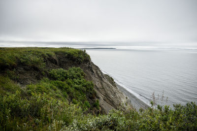 Scenic view of sea and bluffs against sky