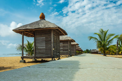 Built structure on beach by sea against sky