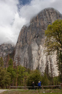 Rear view of people walking on rocky mountain