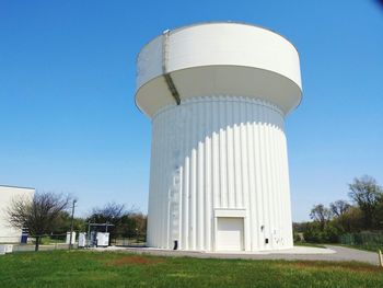 Built structure on field against clear blue sky