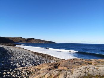 Scenic view of beach against clear blue sky