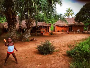 Woman standing by building against trees