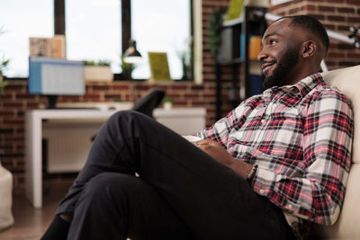 Side view of man sitting on chair