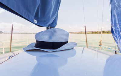 Low section of man on sailboat sailing in sea against sky