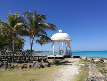 Gazebo by sea against clear blue sky