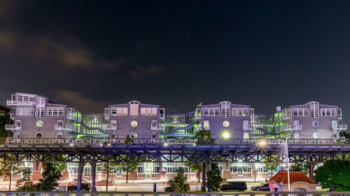 Illuminated buildings in city against sky at night