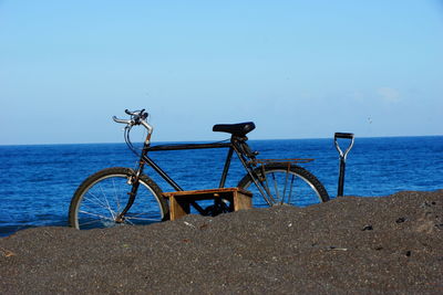 Bicycle on beach against clear sky