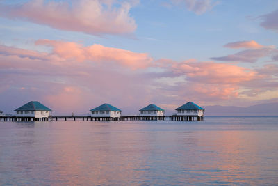 Scenic view of sea and buildings against sky during sunset