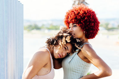 Two attractive latin girls with afro hair in an attitude of love.