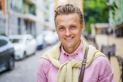 Portrait of young man standing in city