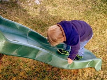 Rear view of boy on slide at park