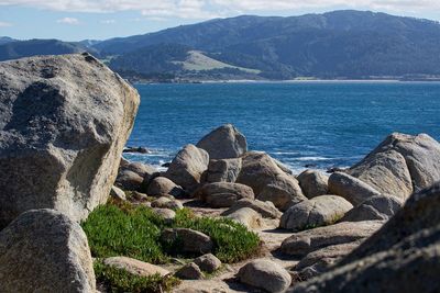 Rocks by sea against sky