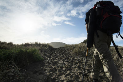 Rear view of man standing on land against sky