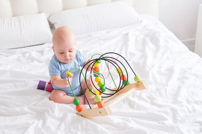 High angle view of cute baby boy sleeping on bed at home