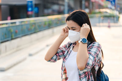 Portrait of young woman drinking outdoors