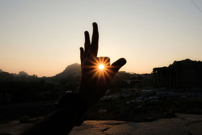 Person holding sun during sunset