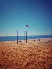 Lifeguard hut on beach against blue sky