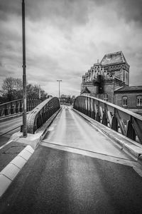 Road by bridge against sky in city