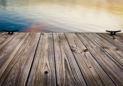 Cleats on jetty over river during sunset