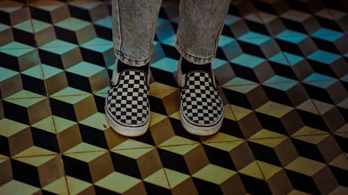 Low section of man standing on tiled floor