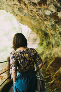 Rear view of woman standing on rock