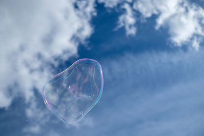 Low angle view of bubble in mid-air against sky