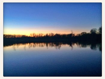 Scenic view of calm lake at sunset