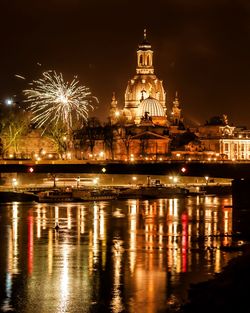 Firework display over city lit up at night