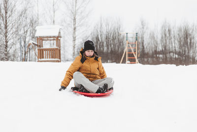 A girl rides down a slide in a winter park, a healthy lifestyle, a sports walk