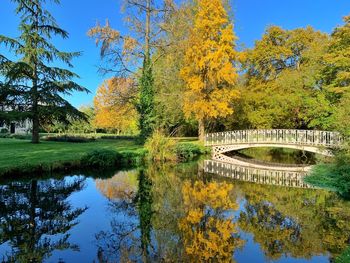 Arch bridge over lake against sky during autumn
