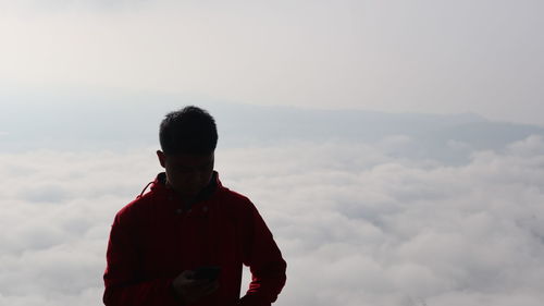 Full length of young man standing against sky