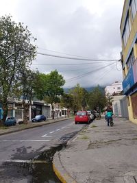 Cars on road against sky in city