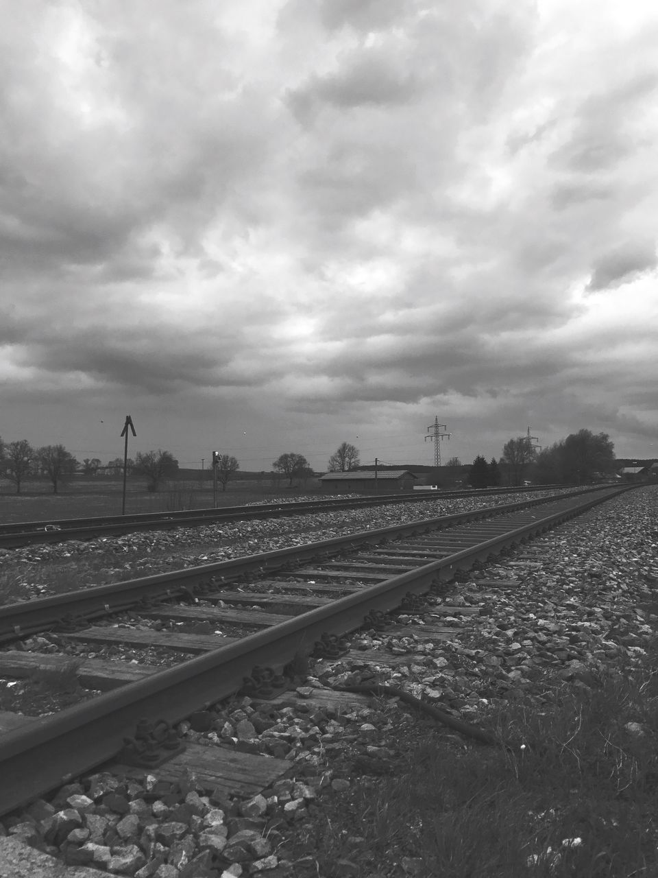 RAILROAD TRACK AGAINST CLOUDY SKY