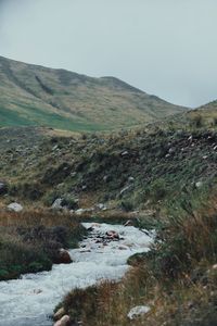 Scenic view of river amidst mountains against sky