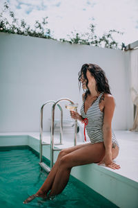 Woman sitting in swimming pool