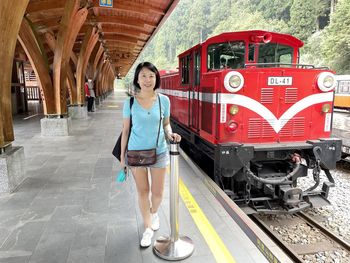 Portrait of young woman standing on railroad track